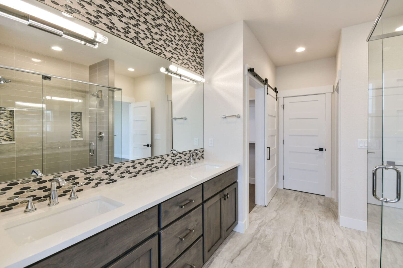 a bathroom with two sinks and a large wall mirror