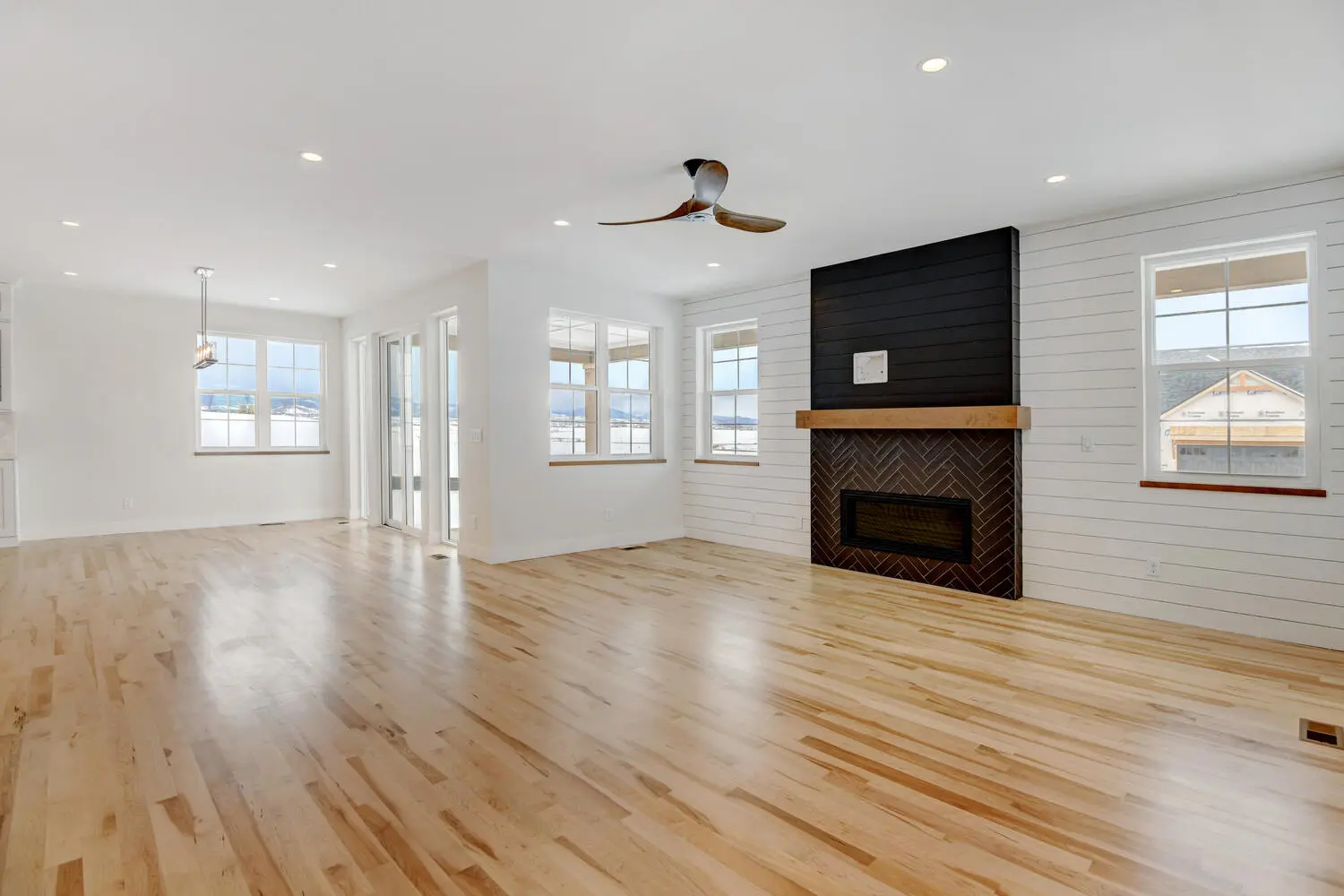 an empty room with a ceiling fan and fireplace