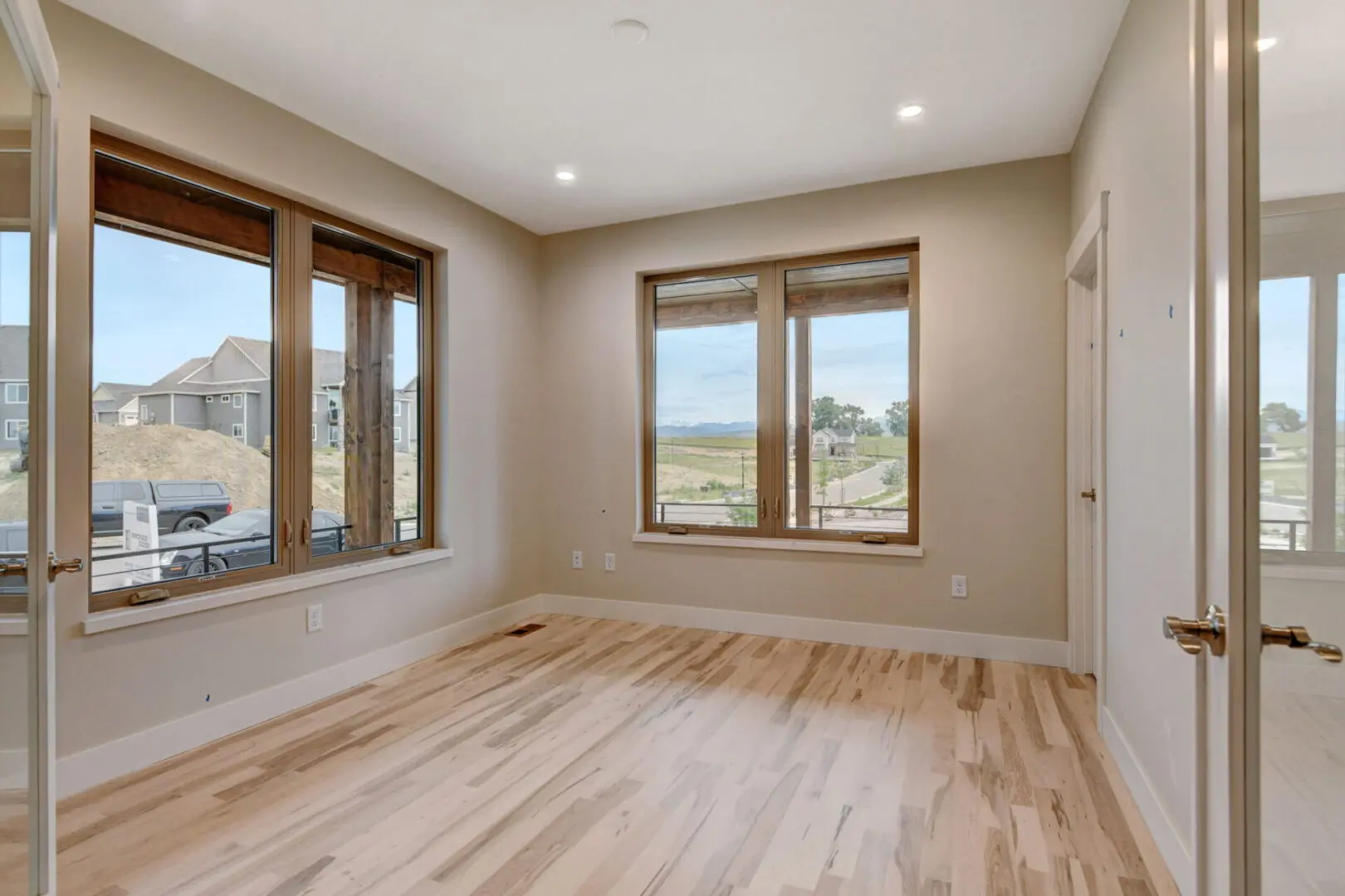 An empty room with windows and wooden floors